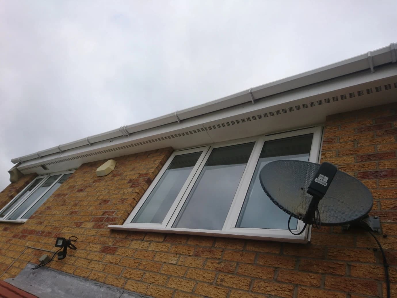 New white UPVC fascia and soffit boards fitted along the roofline of a Merseyside brick property